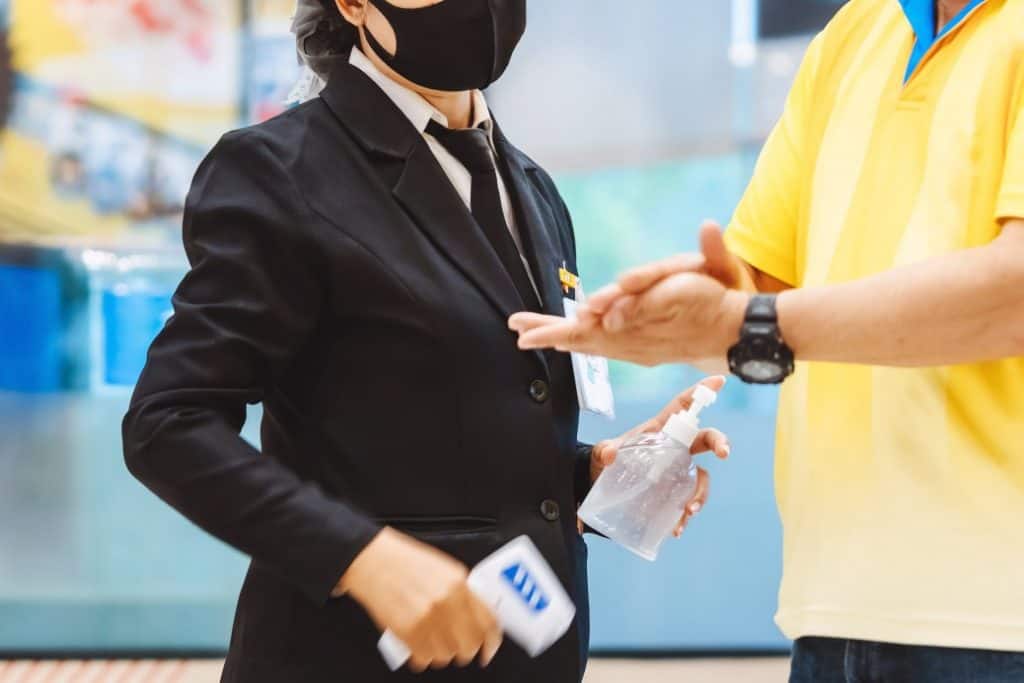 Healthcare Security officer sanitising visitors